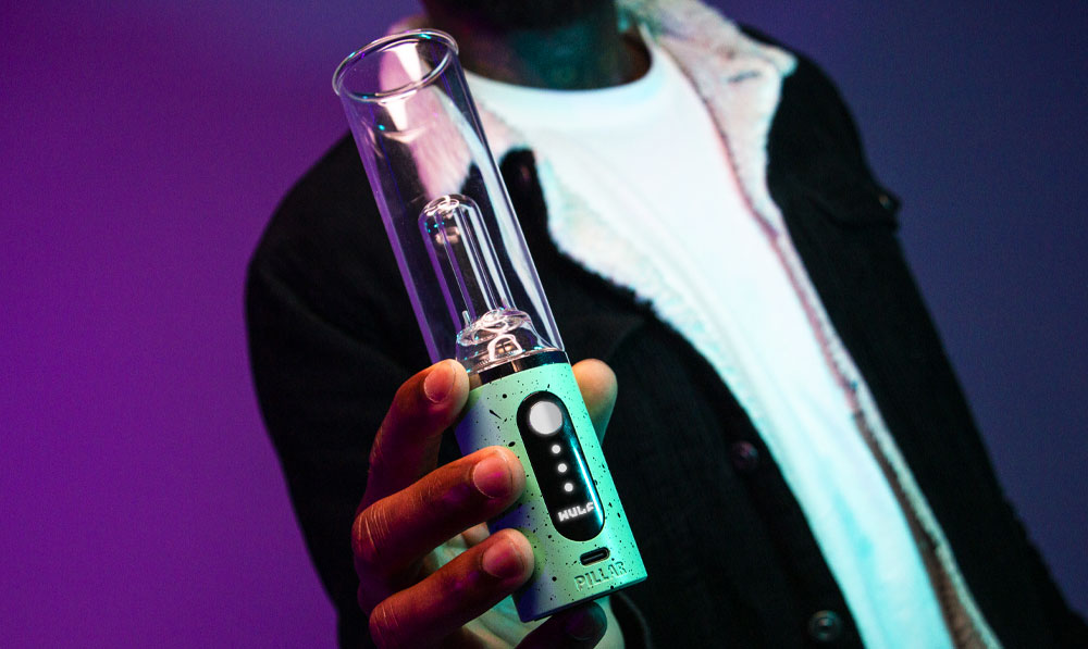 Wulf Mods Pillar Mini E-Rig in man's hands in front of violet background