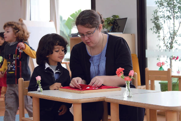 Teacher Using Montessori Resources In A Childcare Centre