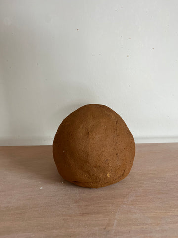 Image of a ball or iron rich clay sitting a top my work bench. 