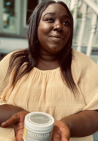 black woman holding candle in white tin