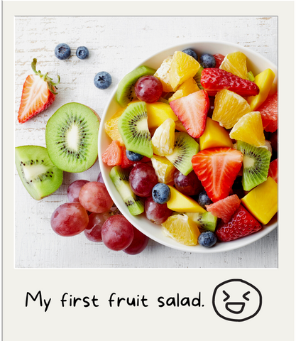 A polaroid of a fruit salad. The text reads, "My first fruit salad." 