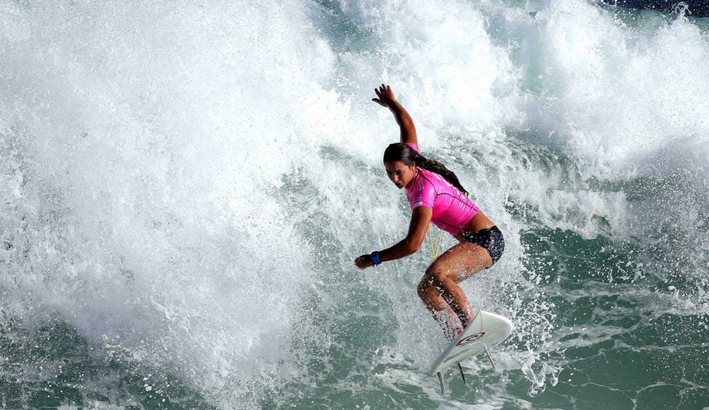 Surfing girl riding a wave