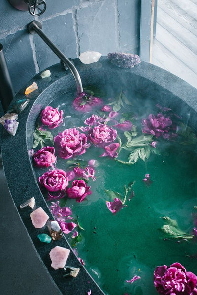 Relaxing bath with flowers and energetic stones