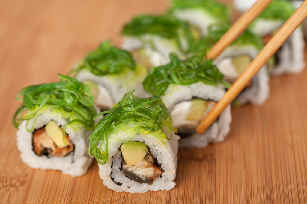 Sushi, rolled with nori (seaweed) and topped with seaweed salad. Photo by Önder Örtel on Unsplash.