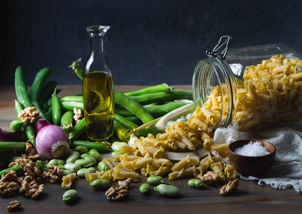 olive oil with common Mediterranean cooking ingredients including vegetables and pasta.