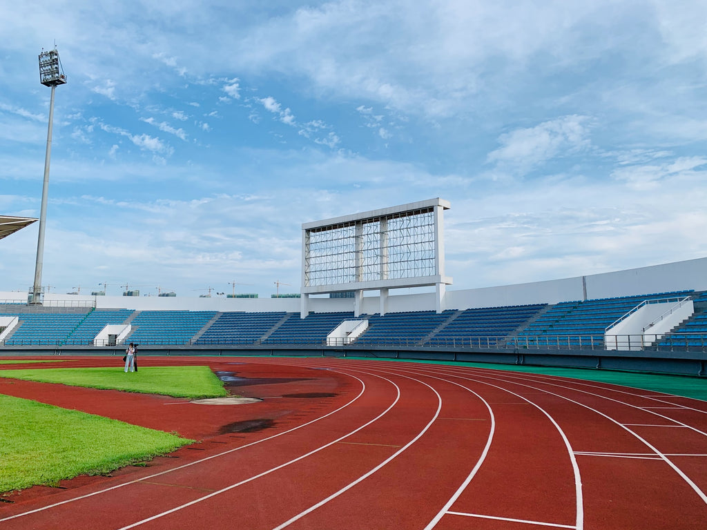 A college running track is pictured with grandstands around it.