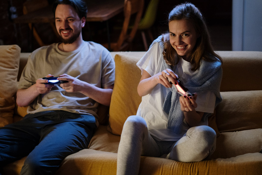 Pärchen mit Controllern auf der Couch