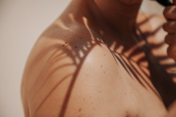 Woman's shoulder with a shadow of a branch