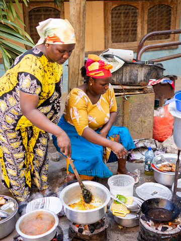 Woman with yellow adire attire cooking