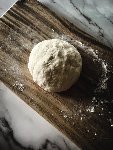 ball of dough on wood board