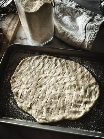 pizza dough on baking sheet