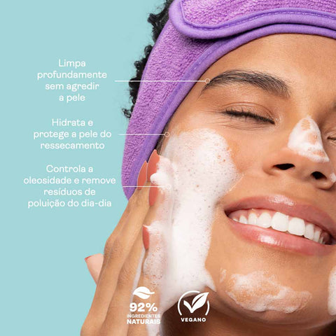 Mulher lavando o rosto com a espuma de limpeza facial da Intua, com informações sobre o produto escritas ao seu lado.