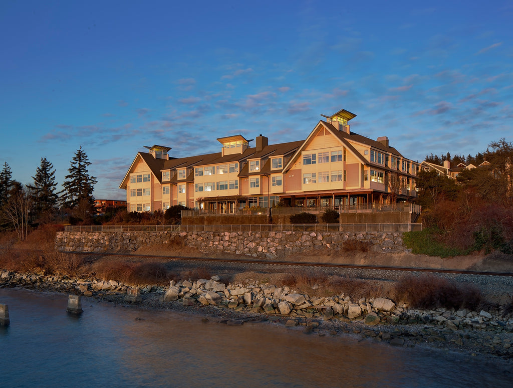 The exterior of the The Chrysalis Inn & Spa Bellingham, Curio Collection by Hilton overlooking a body of water.