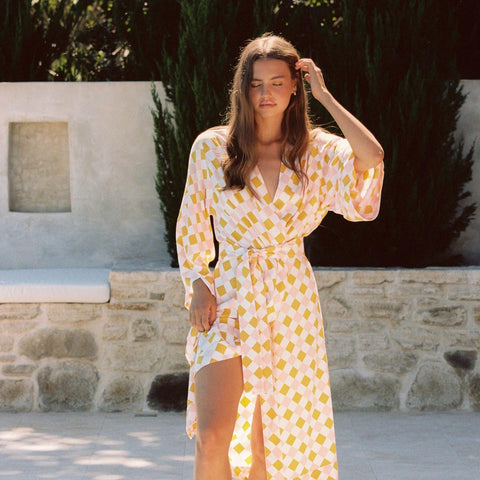 A model wearing the Alice Midi Kimono Robe in Diamond, Orange and Pink from Piyama.