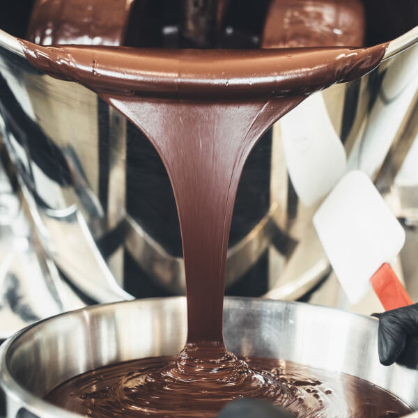 Flüssige Schokolade von Puchero Chocolate wird in Behälter gegossen