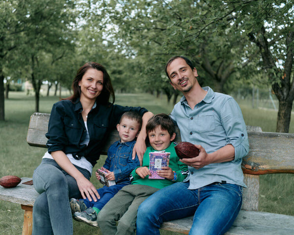 Jitka und Michal von Herufek Schokolade sitzen mit ihren Kindern auf Bank