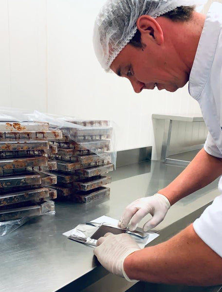 Mark von KRAK Chocolade verpackt eine Schokoladentafel per Hand