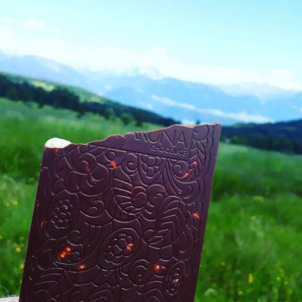 Schokoladentafel von Karuna Chocolate vor Bergpanorama