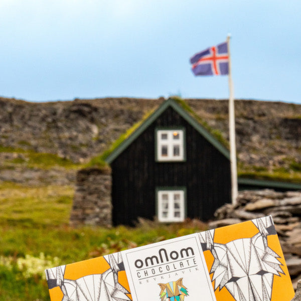 Gelbe Omnom Schokoladen vor Holzhütte mit isländischer Flagge