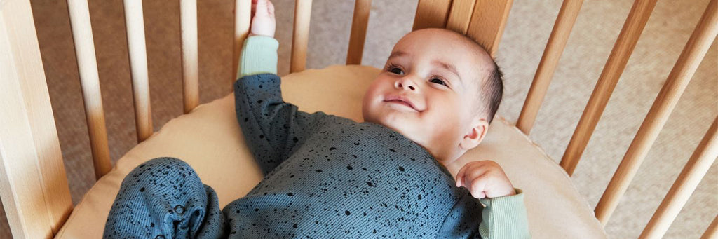 A baby in the Stokke Sleepi Mini crib.