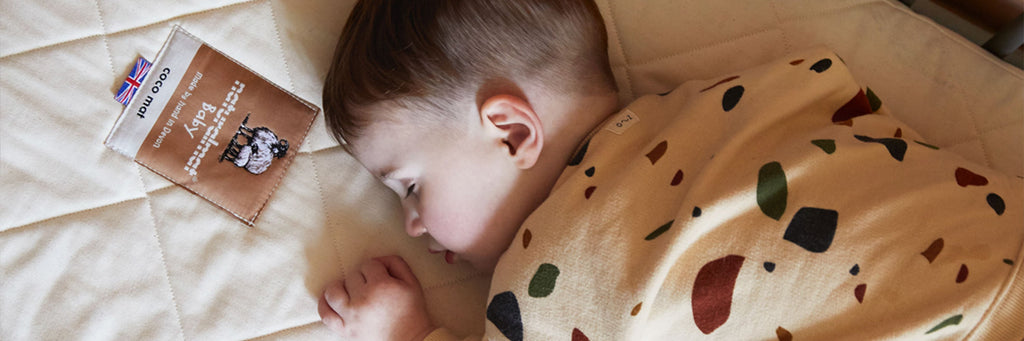 A toddler sleeping on a Naturalmat Baby mattress.