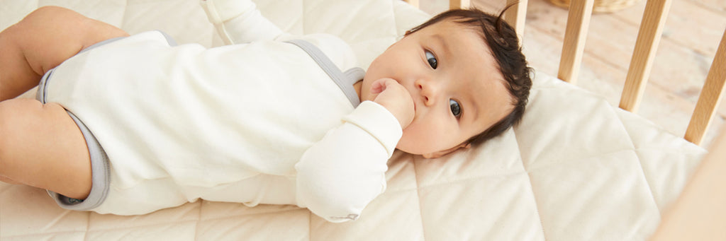 A baby lying on a Naturalmat Baby mattress.