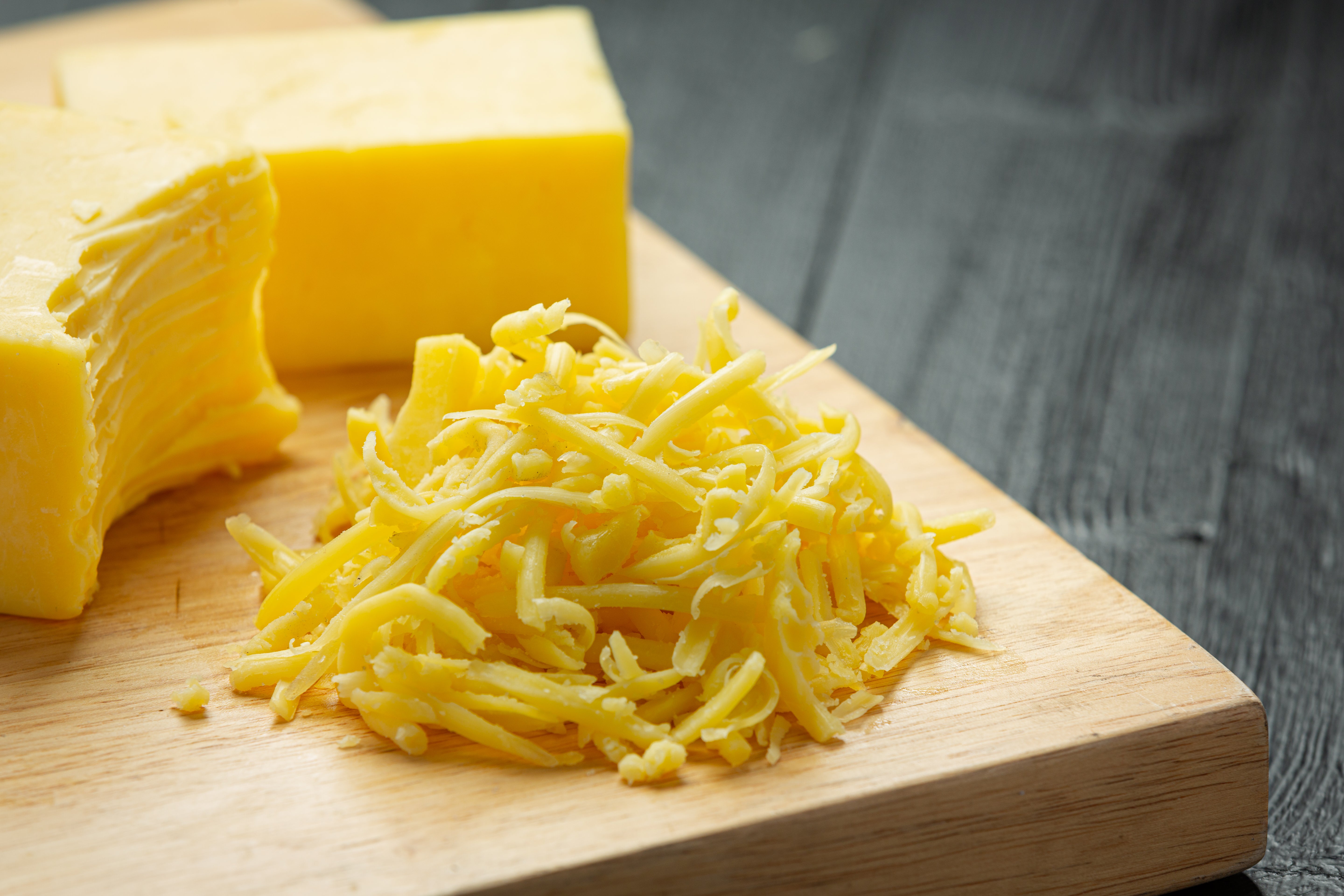 cheddar-cheese-dark-wooden-surface.jpg__PID:7e2bf61d-2e96-49a3-b3cf-1aa986f86867