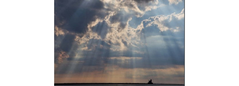 Duane Thomas beautiful sun and clouds with lighthouse presented by H Lee White Maritime Museum near Oswego NY
