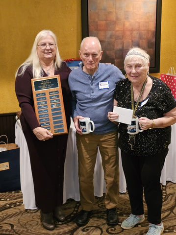 Mercedes Niess presents Gail and Ned Goebricher with Volunteer of Year award.