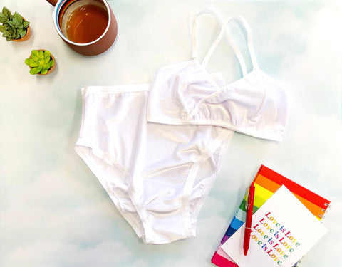 white velvet lingerie set on cloud background with cup of tea and notebook beside it