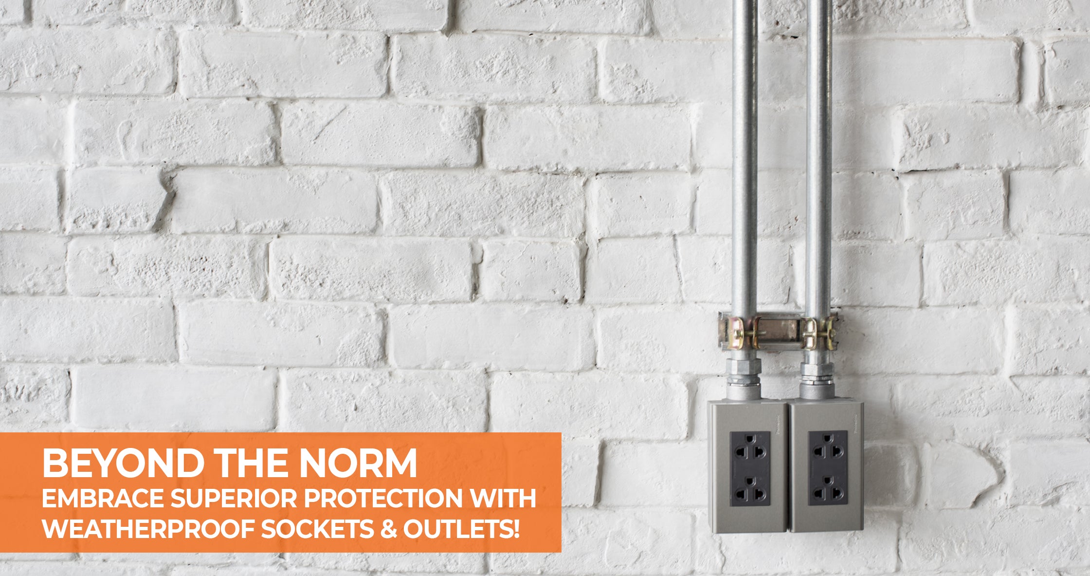 Double weatherproof electrical sockets in a gray casing attached to metal conduit pipes on a white brick wall, with text overlay 'Beyond the Norm: Embrace Superior Protection with Weatherproof Sockets & Outlets!