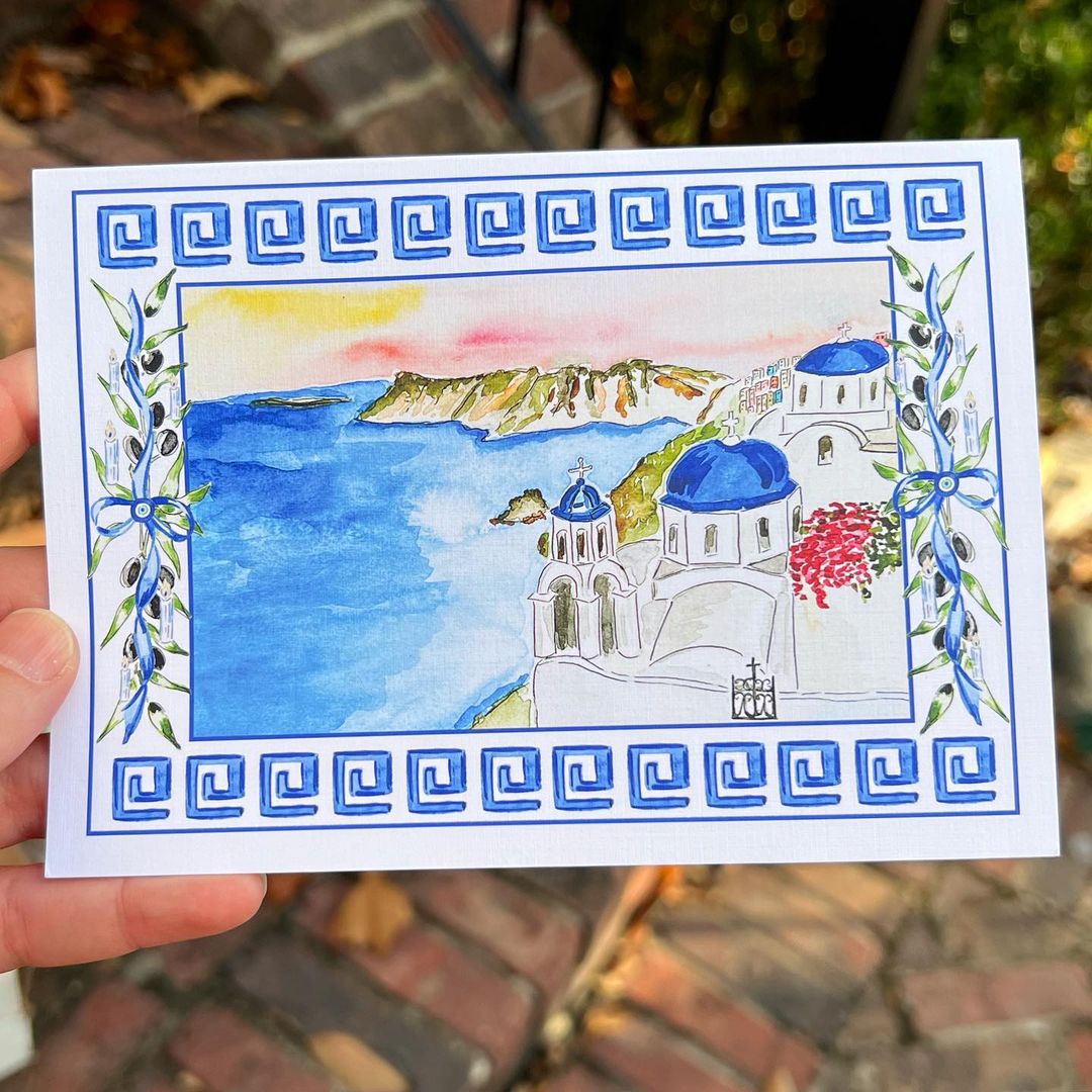Santorini seascape painted in watercolour with a blue Mediterranean style border.