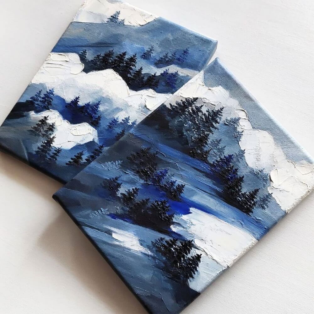 Two canvases sitting together with a winter landscape of trees in snow.