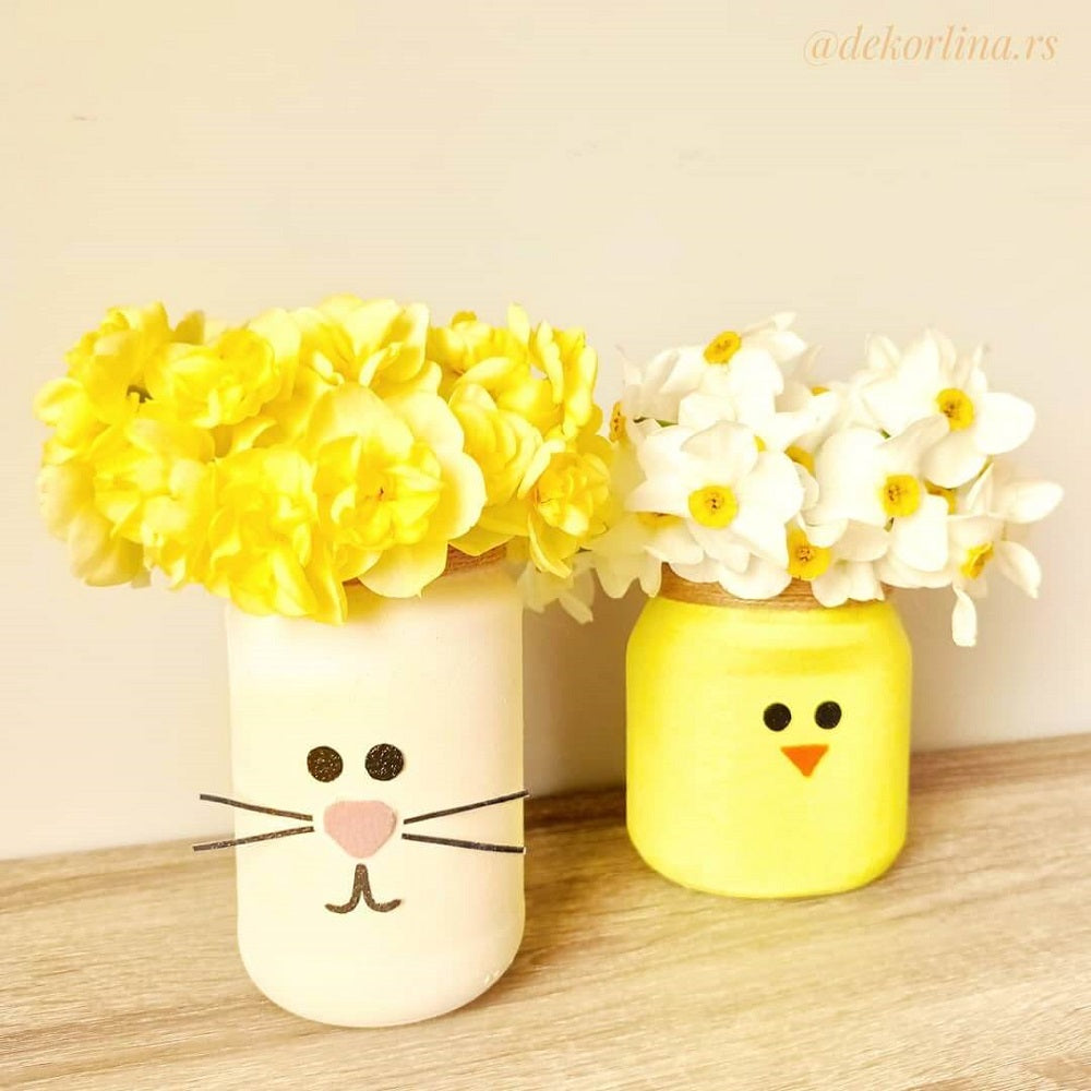 A bunny vase and a small chicken vase made from mason jars with yellow and white spring flowers in each.