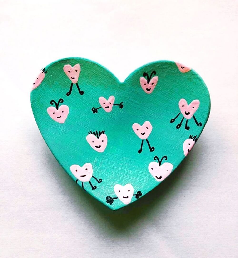 A heart dish made from clay painted green.