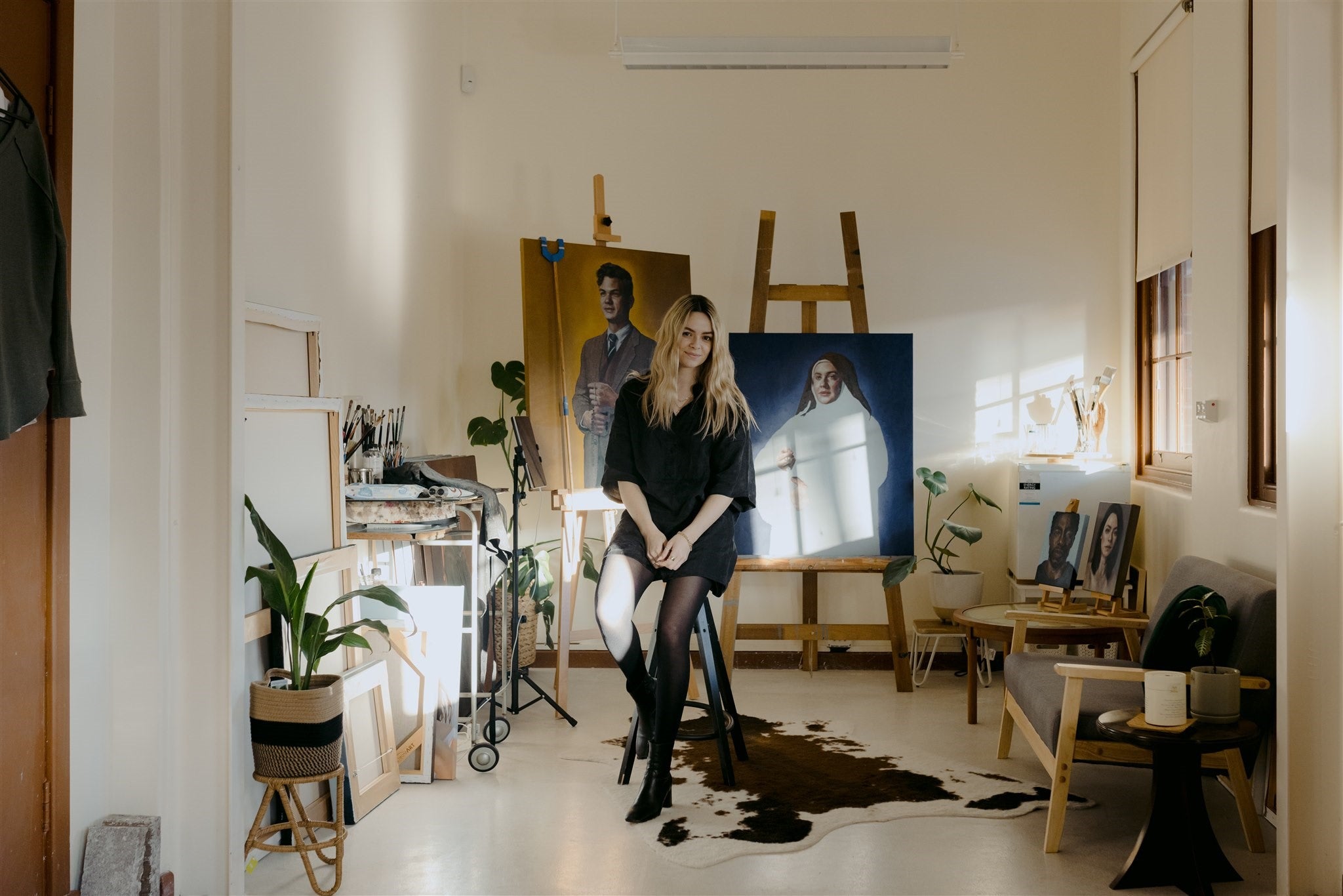 Rachelle dusting sitting on a chair in her studio.