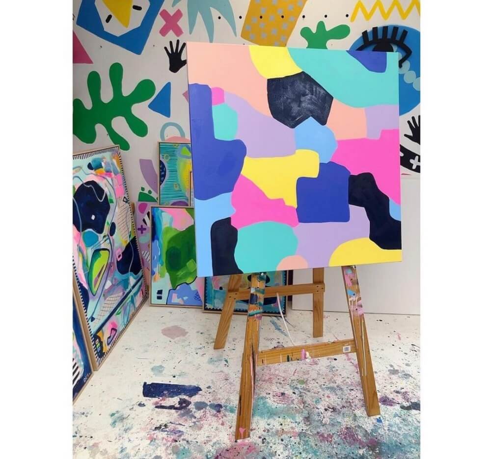 Colourful splats painted on to a canvas in a colourful art studio.