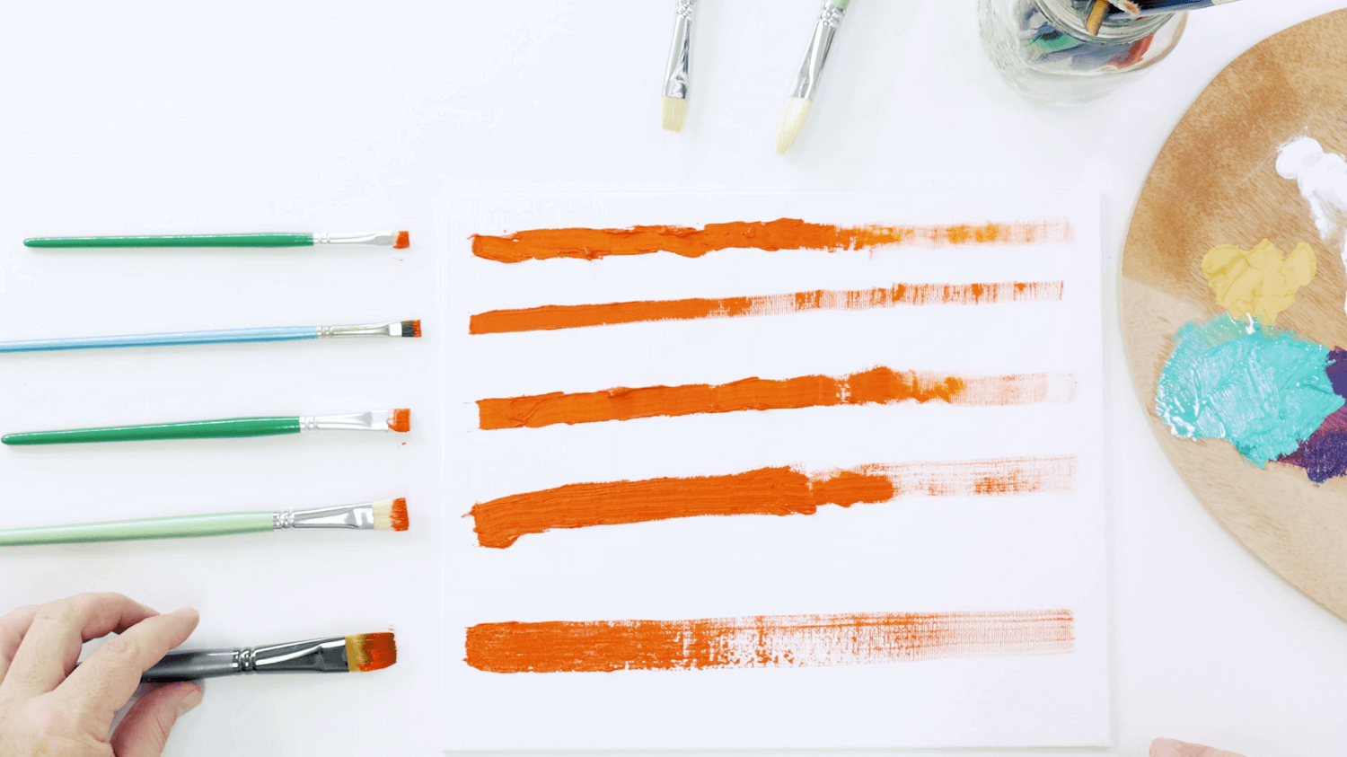 Orange oil paint with various sizes of bright oil paint brushes.