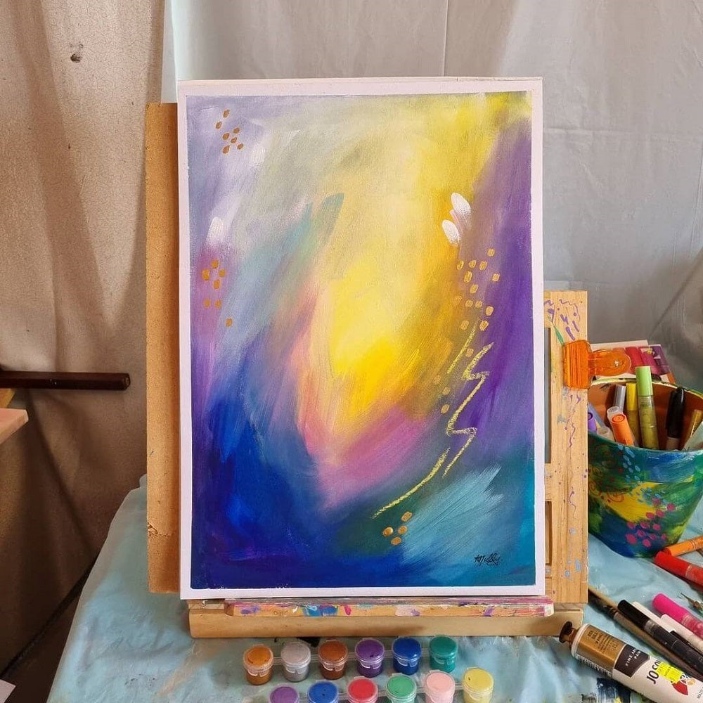 A coloured artwork of purple and yellow on wooden easel.