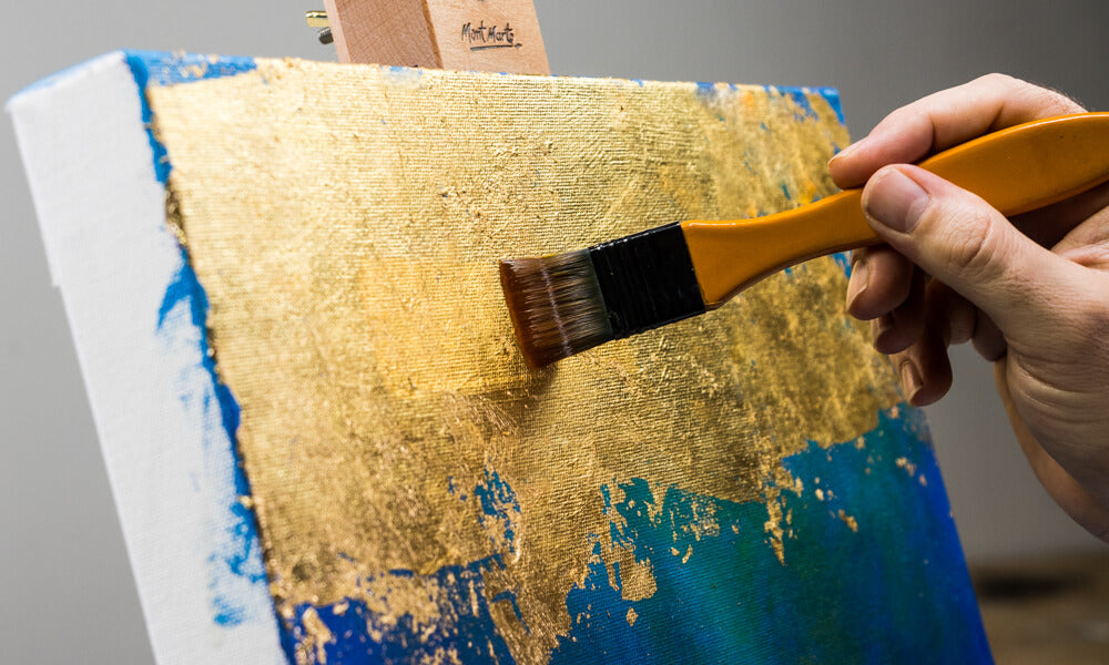 Paint brush sealing the gold leaf with varnish.