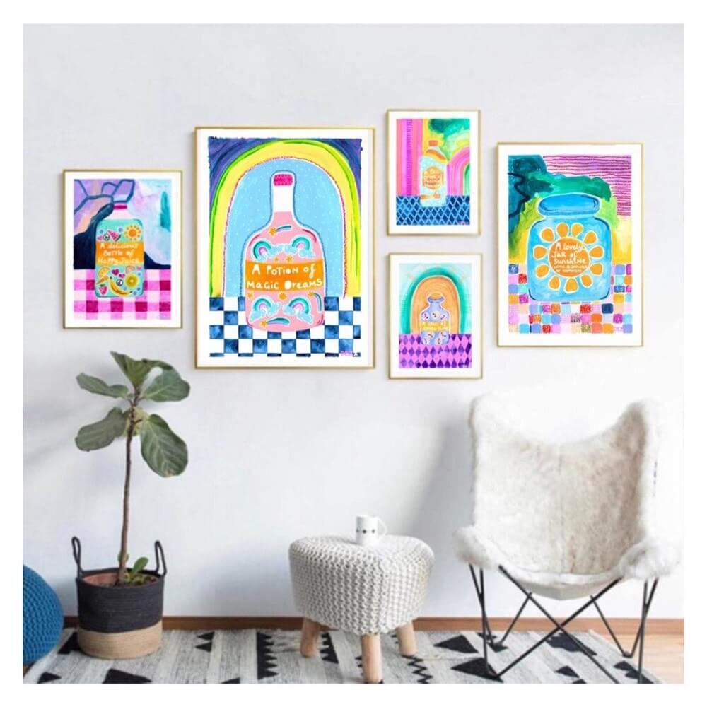 White living room with 5 different sized frames of abstract paintings of bright jars.