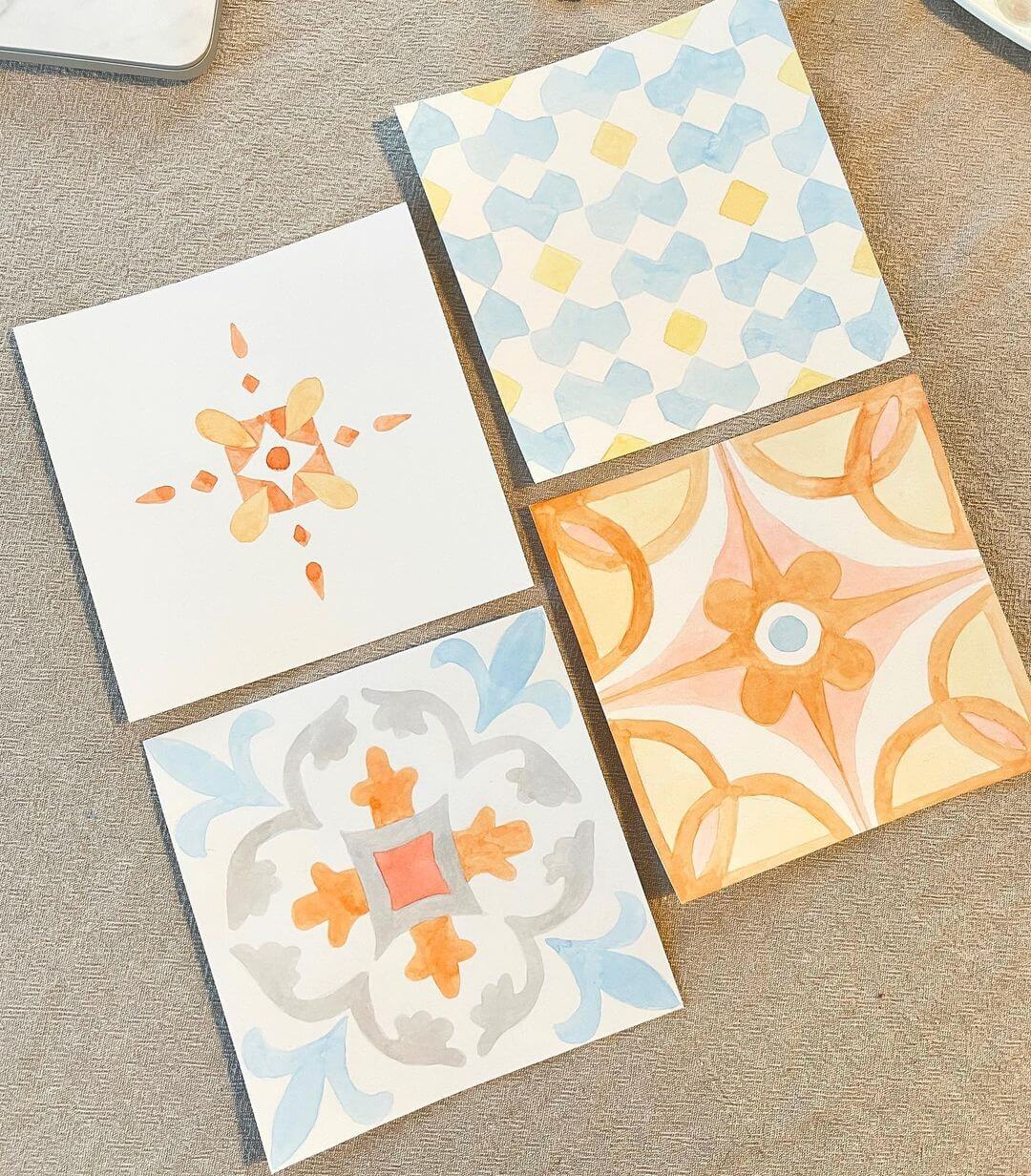 Four Mediterranean style tiles, each with different designs and painted in watercolour.