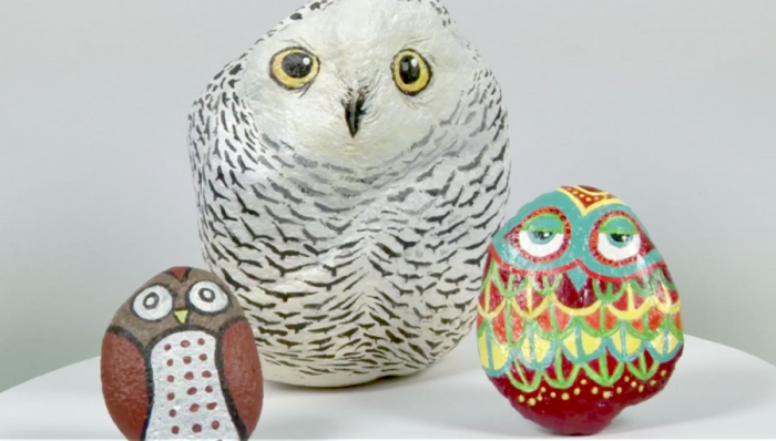 Three owls painted on rocks to look realistic.