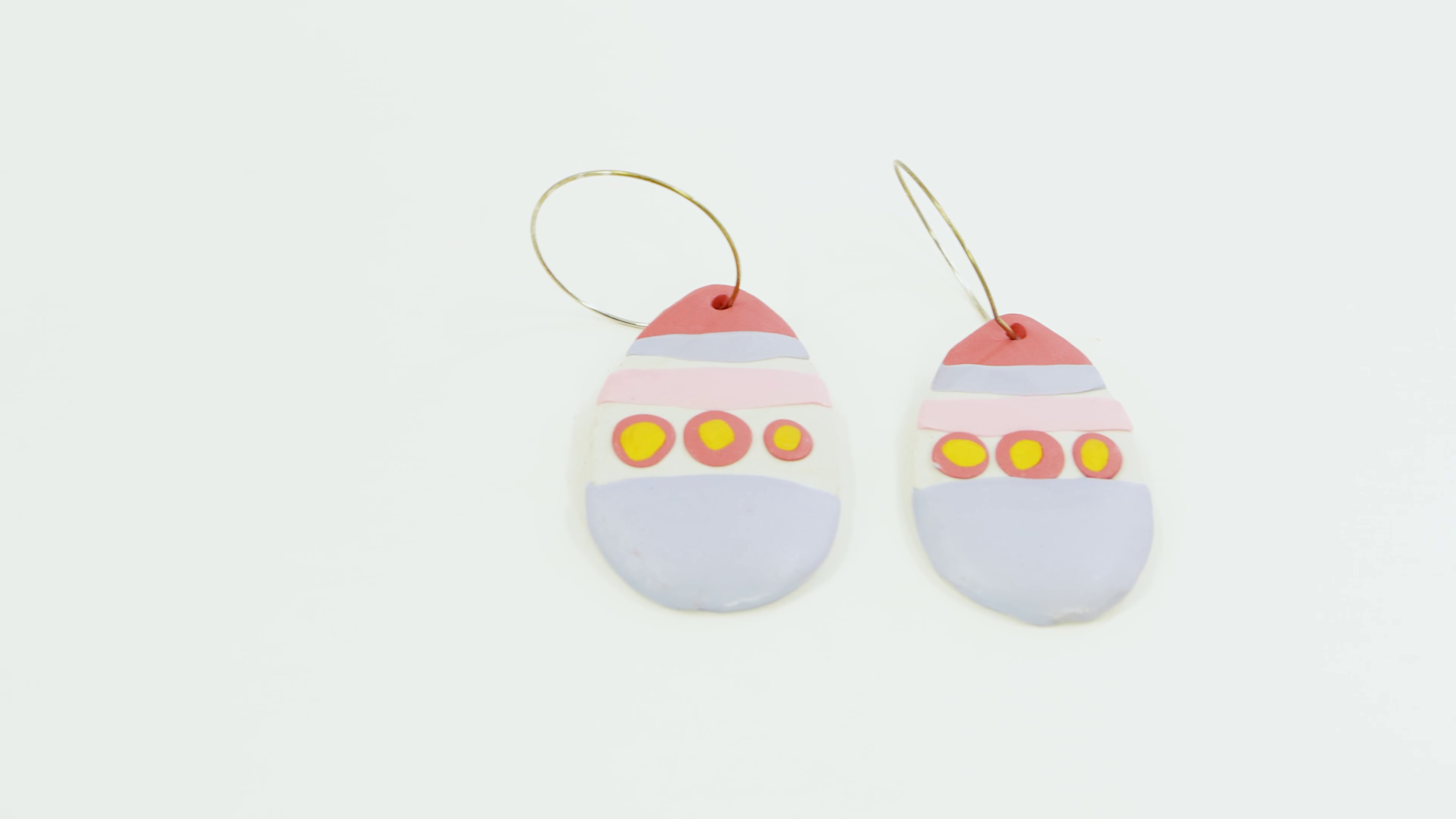 A pair of coloured Easter egg earrings made from polymer clay.