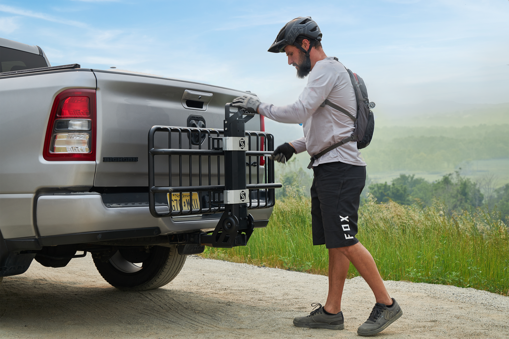 Man folding the mhs cargo hitch rack on vehicle