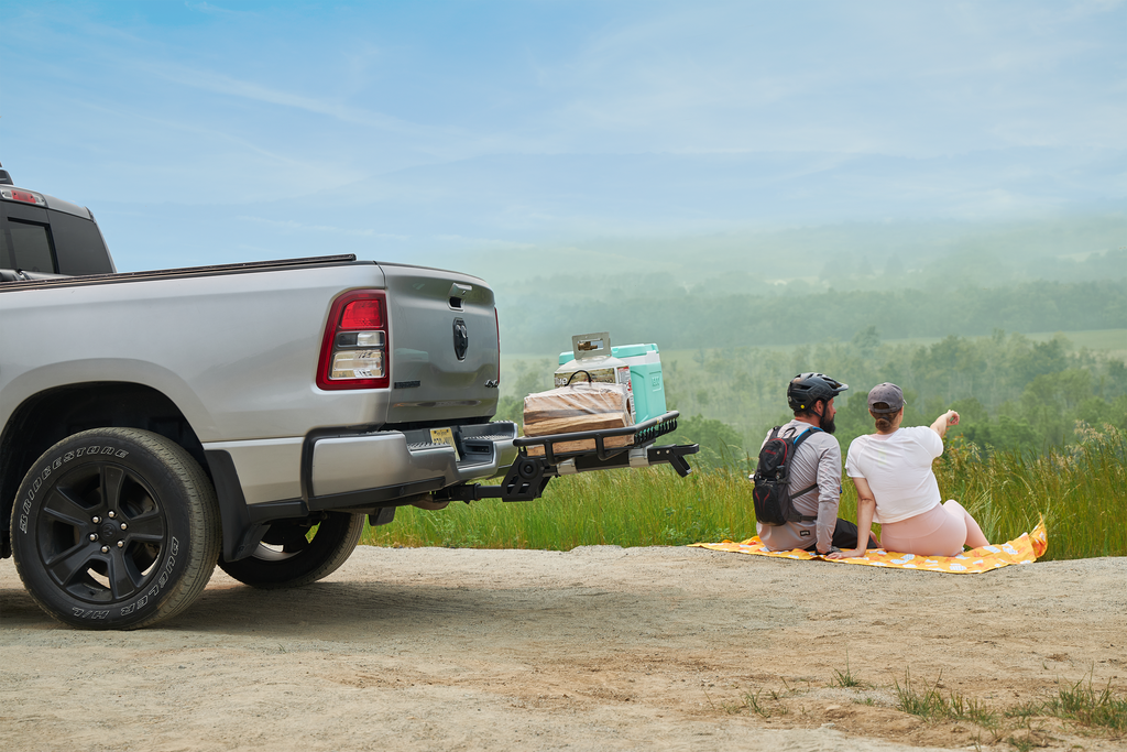 Man and woman picnicing next to the mhs cargo basket hitch rack