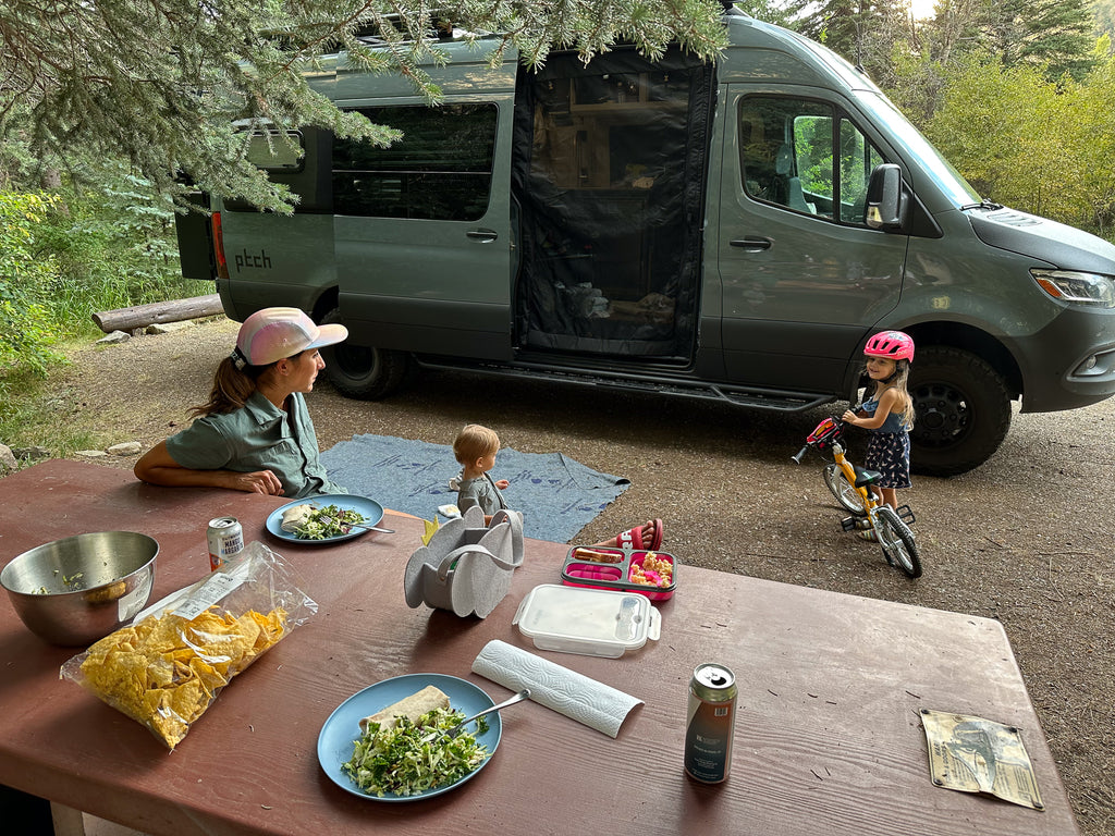 Family camping next to an RV with the mhs hitch rack
