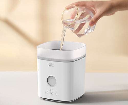 User effortlessly refilling the Puffing Humidifier from the top, showcasing the 560ml capacity and lid-free design