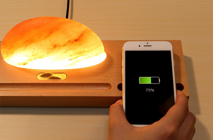 Sun Of the East - Himalayan Salt Lamp on a wooden stand providing wireless charging, combining functionality with natural wellness