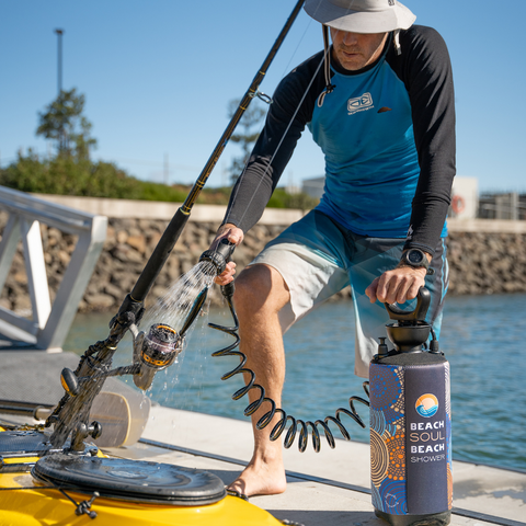 Man washing his fishing rod on jetty